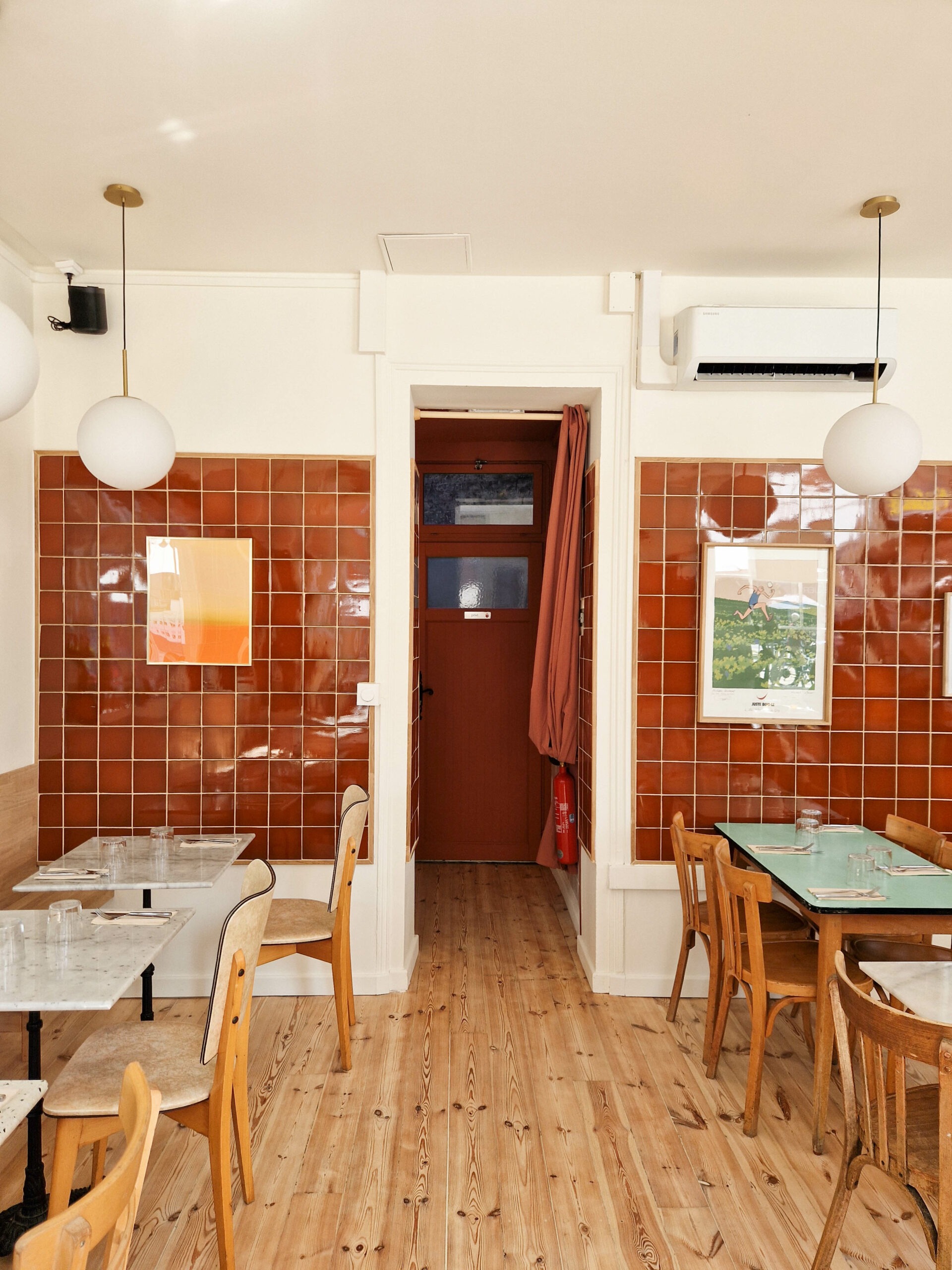 Aménagement du restaurant Pickles à Lille avec salle structurée, circulation centrale et murs en carrelage terracotta